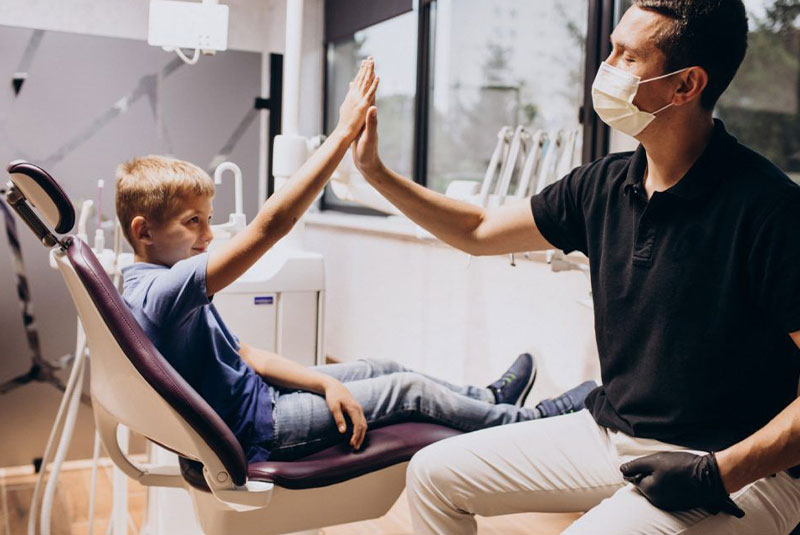 child patient giving the doctor a high five within the dental center